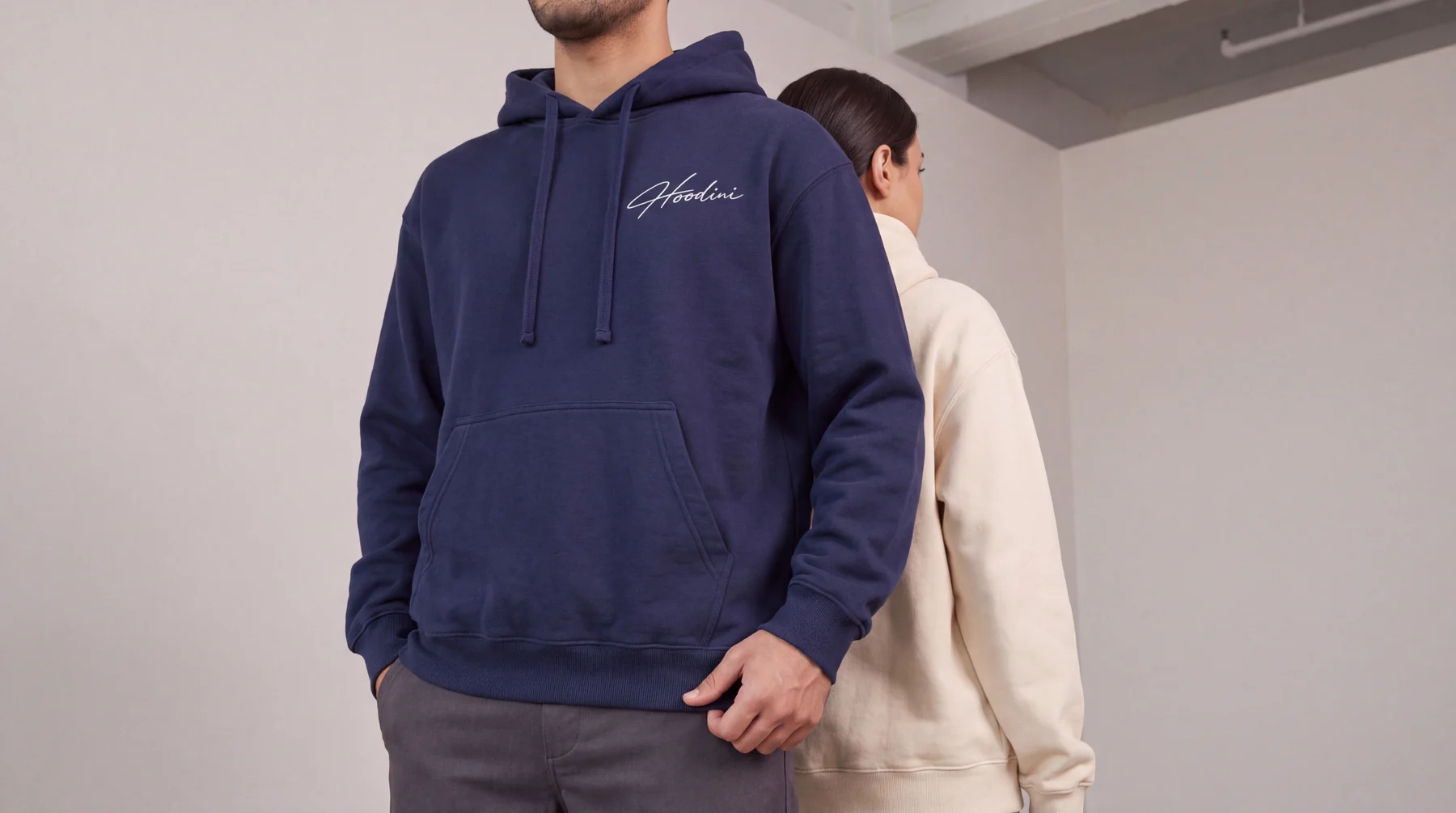Two models wearing Hoodini hoodies in navy and beige